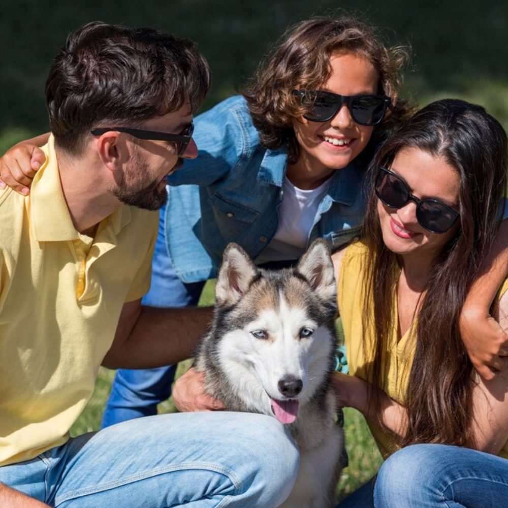 Parents and child spending time together with dog at the park