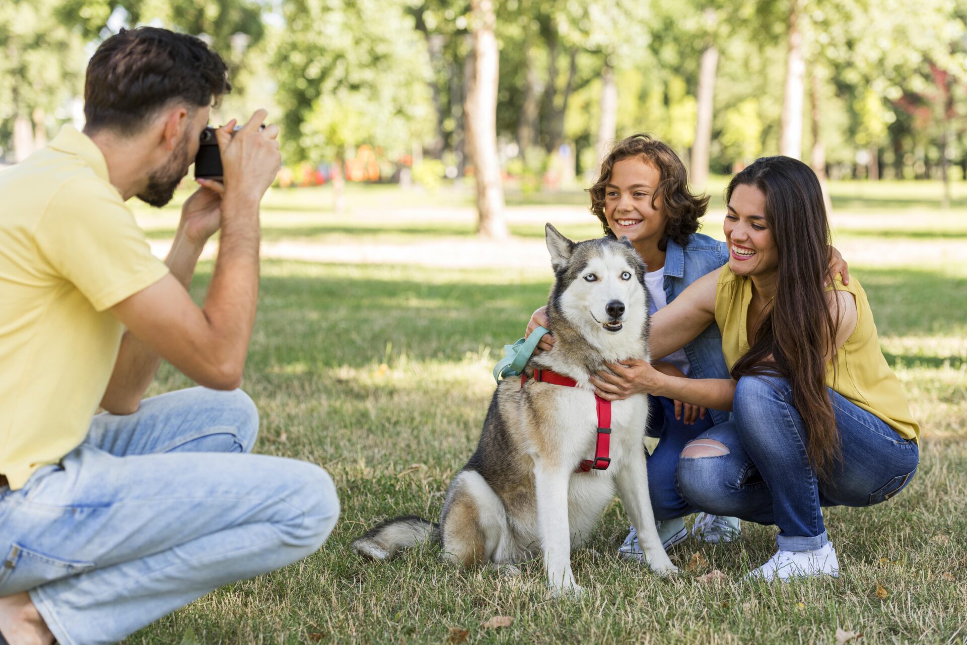 father-taking-pictures-mother-son-with-dog-park